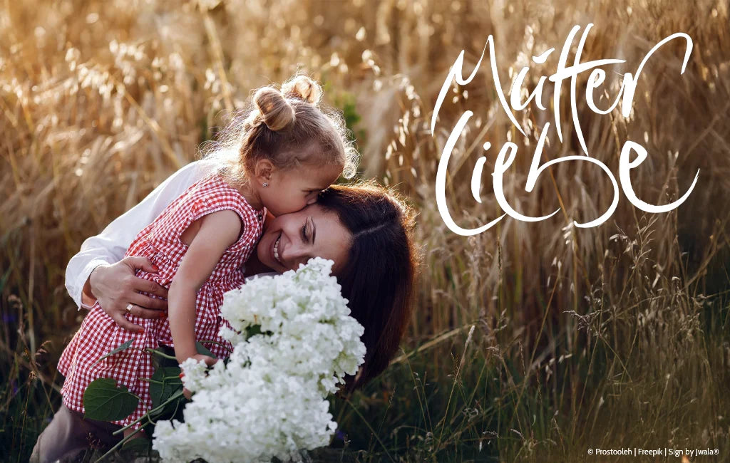 Mutter mit Mädchen in der Wiese, daneben die Jwala® Botschaft „Mutterliebe“ – aus dem Onlineshop SignShop Tirol.