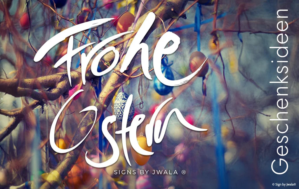 Ostereier an Ästen und der weiße Schriftzug „Frohe Ostern“ im Jwala® Stil im Vordergrund aus dem Onlineshop SignShop Tirol.