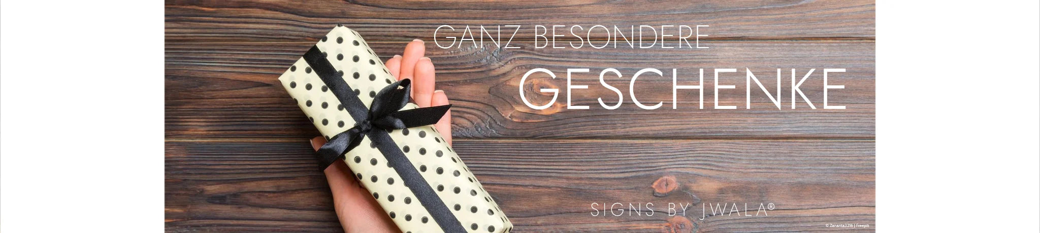 Geschenk auf einem Holzhintergrund – liebevoll verpackt aus dem Onlineshop SignShop Tirol