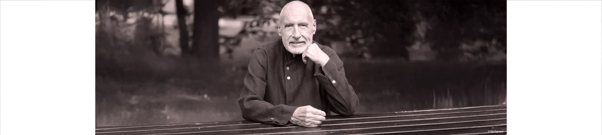 Das Bild zeigt Karl Gamper mit einem offenen, herzlichen Blick direkt in die Kamera. Der schlichte Hintergrund lenkt die Aufmerksamkeit ganz auf Karl Gamper, wodurch eine Atmosphäre von Wärme, Echtheit und Inspiration entsteht.