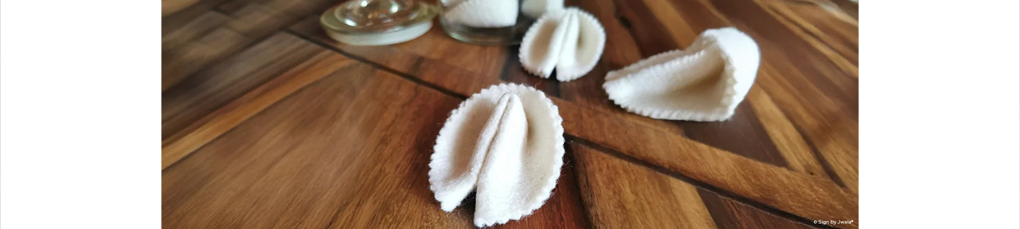 Das Bild zeigt handgemachte Glückskekse aus dem SignShop Tirol, die jeweils einen kleinen Zettel mit einer inspirierenden Botschaft oder einem Spruch enthalten. Die Glückskekse sind liebevoll arrangiert und laden dazu ein, Freude und positive Gedanken zu verschenken.