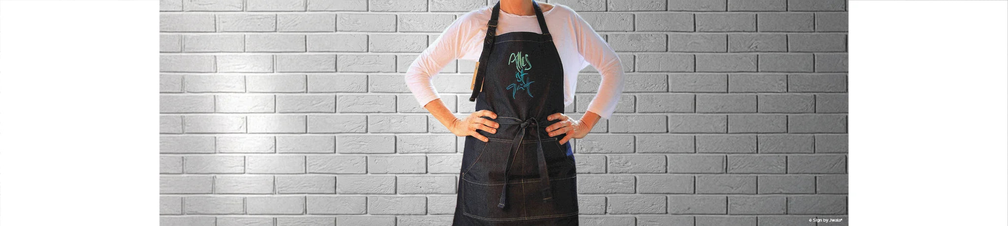 Schürze mit der Botschaft „Alles ist gut“ aus dem Onlineshop SignShop Tirol – handgemacht, inspirierende Küchenkleidung, liebevoll gestaltet, positive Affirmation.