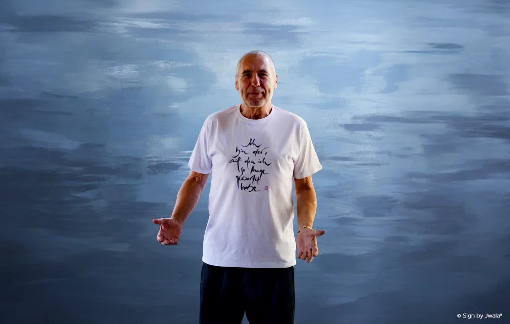 Weißes T-Shirt für Männer mit der Botschaft „Ich bin der, auf den ich so lange gewartet habe“ aus dem Onlineshop SignShop Tirol – handgemachte Mode, inspirierende Männerkleidung, positive Affirmation, Tiroler Handwerkskunst.