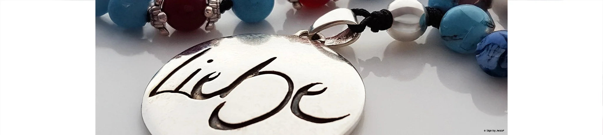 Malas mit der Botschaft „Liebe“ und verschiedenen Edelsteinen aus dem Onlineshop SignShop Tirol – handgefertigter, spiritueller Schmuck für Achtsamkeit und innere Ruhe.