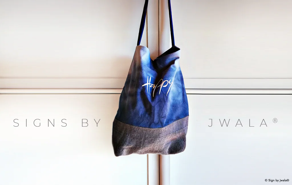 Blaue Tragetasche aus Bauernleinen mit der Botschaft „Happy“ aus dem SignShop Tirol.