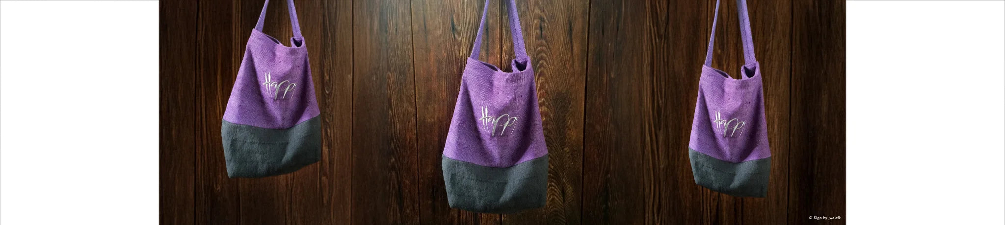 3 Lila und schwarze Tragetaschen aus Bauernleinen mit der Botschaft „Happy“ aus dem SignShop Tirol.